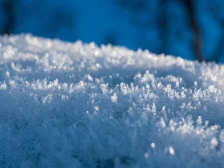 Ice crystals on snow with blue backgroundの写真素材