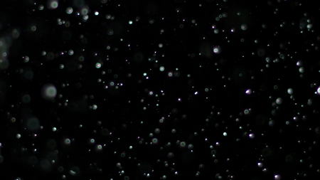 Snowfall Bokeh Lights on Black Background, Shot of Flying Snowflakes in the Airの写真素材
