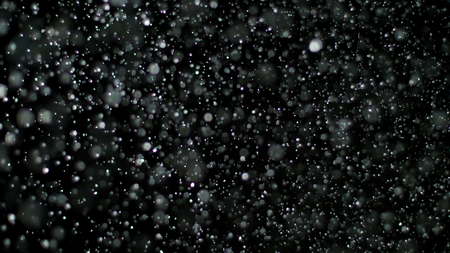 Snowfall Bokeh Lights on Black Background, Shot of Flying Snowflakes in the Airの写真素材