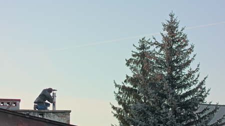 Builder man worker screwing self tapping screw with screwdriver machine during roofing construction worksの写真素材
