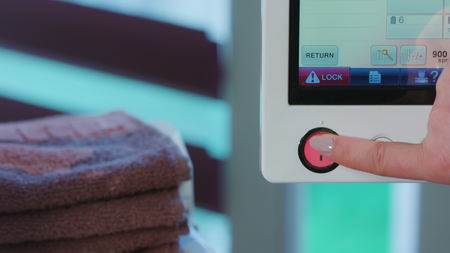 woman sets up the program for the embroidery on the fabricの写真素材