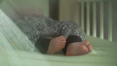 Childrens feet in the pants moving in bed