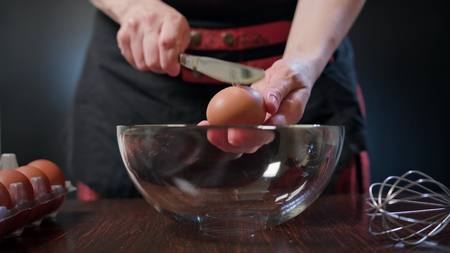 Female hands breaking an egg and separating yolk from white. Close-up shotの写真素材