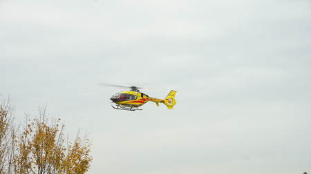 Lublin, Poland - Nowember 2016: Yellow helicopter taking off against a grey sky. Long shot.のeditorial素材