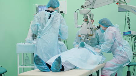 Team of ophtalmology surgeons and assistants with ophtalomological surgery tools during surgical...