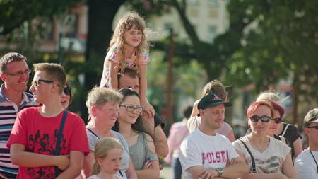 Lublin, Poland - July 2017: Kids and adults are laughing and claping while watching street performance of juggler within Festival Sztukmistrzow staying on the street. Father holds his daughter on his shoulders. Sunny. Outdoor. Medium. Stabilizedのeditorial素材