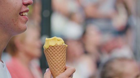 Lublin, Poland - July 2017: Teen boy eats an ice cream while watching the Mattatoio Sospesos aerial dance and clown show Out during Festival Sztukmistrzow. Sunny. Afternoon. Close up. Stabilizedのeditorial素材
