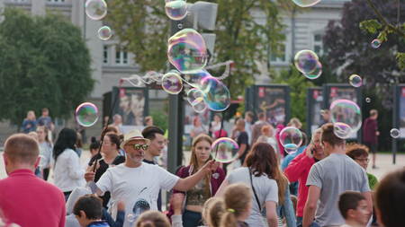 Lublin, Poland - July 2017: Many people walk along the Litewski Square on summer day. Mid-aged man makes soap bubbles. Trees and buildings on the background. Sunny. Outdoor. Medium. Stabilized.のeditorial素材