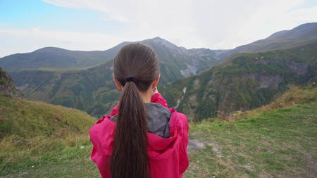 A young lady taking photos in the mountains. Medium shot.