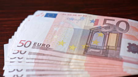 Fanned pile of fifty euro banknotes on a table. Close-up shot
