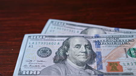 Fanned pile of hundred dollar banknotes on a table. Close-up shotの写真素材