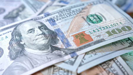 A pile of hundred dollar banknotes on a table. Close-up dolly shot