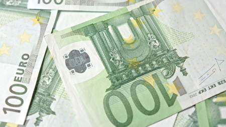 A pile of hundred euro banknotes on a table. Close-up dolly shot