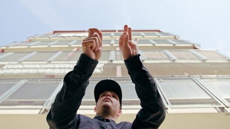 A young man dressed in black breakdancing in the street. Close-up shotの写真素材