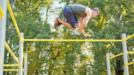 Pull-up strength training exercise. Slim athlete a very fit guy fitness instructor or a personal...