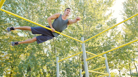 Pull-up strength training exercise. Slim athlete a very fit guy fitness instructor or a personal...