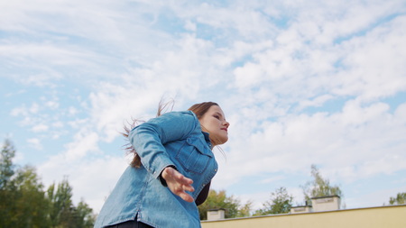 A young woman dancing outside. Medium shot