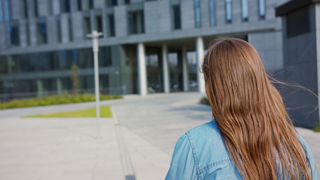 A young woman walking outdoors. Medium shot