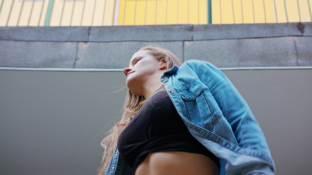 A young woman dancing in the courtyard. Medium shotの写真素材