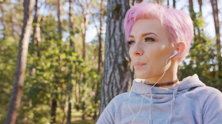 A young y with pink hair stretching in the forest. Close-up shotの写真素材
