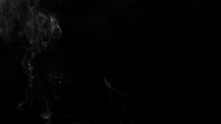 White clouds of vapor smoke are isolated on a black background. Gas explodes, swirl and dances in space. A magic fog dust texture effect that can be used by overlay and changing their transparency.の写真素材