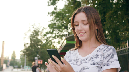 An attractive young lady using a phone in town. Close-up shot. Soft focusの写真素材