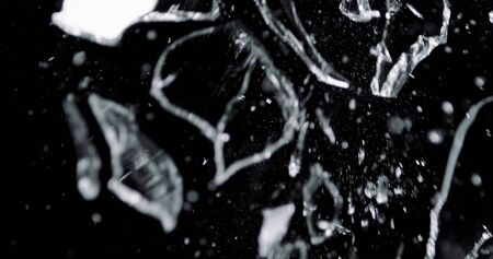 Shattered and broken glass shards flying through the air after crush broken window on a black backgroundの写真素材