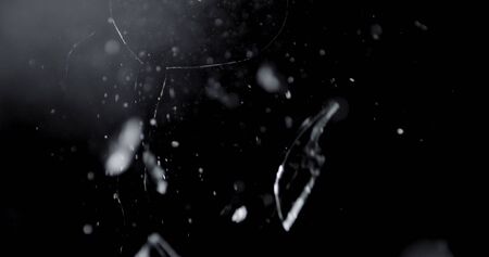 Shattered and broken glass shards flying through the air after crush broken window on a black backgroundの写真素材