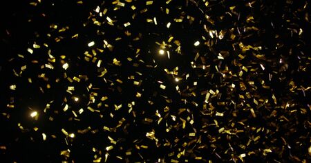 Confetti fired in the air during a party. Only confetti on black background of the night. Falling metallic glitter foil confetti multicolor in black background.の写真素材