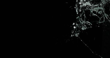 Real frost on a window. Frostwork pattern ice crystals on black background. Dark surface with...