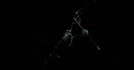 Real frost on a window. Frostwork pattern ice crystals on black background. Dark surface with...