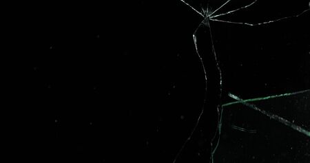 Real frost on a window. Frostwork pattern ice crystals on black background. Dark surface with...