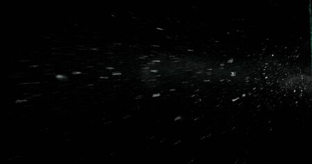 Real frost on a window. Frostwork pattern ice crystals on black background. Dark surface with...