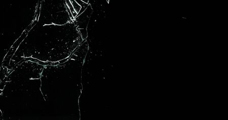 Real frost on a window. Frostwork pattern ice crystals on black background. Dark surface with...