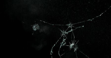 Real frost on a window. Frostwork pattern ice crystals on black background. Dark surface with...