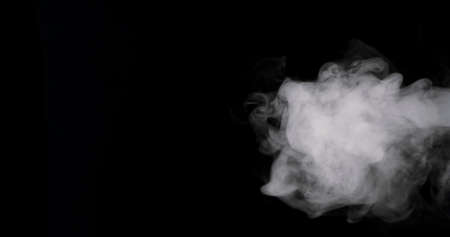 plume of thick smoke flowing in against a black background.