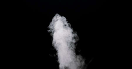 plume of smoke bubbling up against a black background.の写真素材