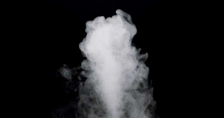 plume of smoke bubbling up against a black background.の写真素材