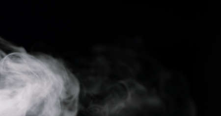 swirling white cloud of smoke against a blackの写真素材