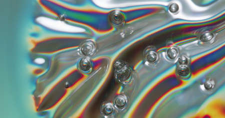 Iridescent bubbles forming on a metallic surface as it heats up.