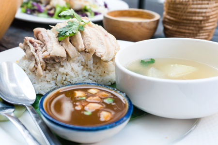 Rice, chicken, soup and sauce are in white and banana in restaurant with server for customers.front viewの写真素材