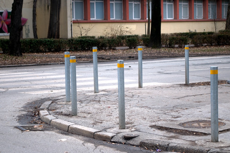 Row metal poles along the road to control the movement of the car in Novi Sad, Serbiaの写真素材