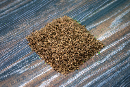 Various forms of carum carvi on a wooden background