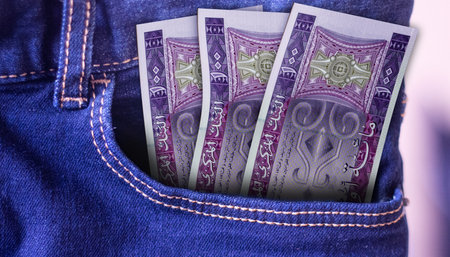 Bunch of Mauritania 100 Ougiya banknotes in a jeans pocket a concept of spendingの写真素材