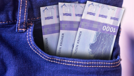 Bunch of Norway 1000 Kroner banknotes in a jeans pocket a concept of spending