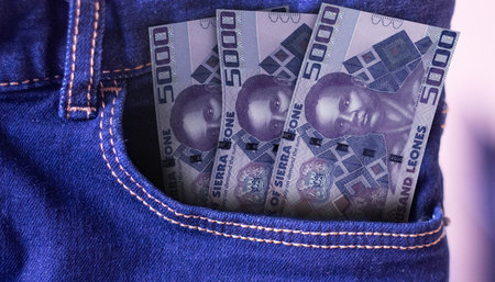 Bunch of Sierra Leone 5000 Leones banknotes in a jeans pocket a concept of spending