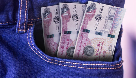Bunch of United Arab Emirates 100 Dirham banknotes in a jeans pocket a concept of spending