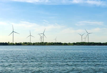 Windmills behind the lake. Wind power. Green energyの写真素材
