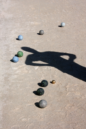 Balls and man shadow on the ground of bocce ball courtの写真素材