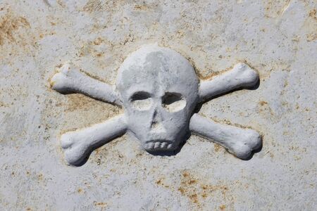 Death head on ancient tombstone in graveyard in Stari Grad, Hvar island, Croatiaの写真素材